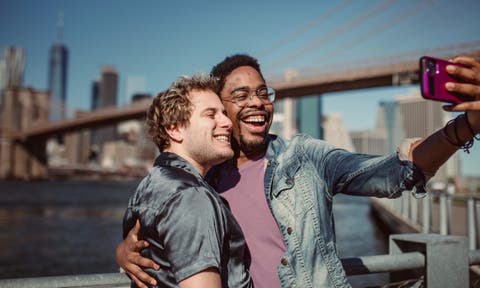 Zwei menschen lächeln, Skyline und Brücke im Hintergrund. Handy, Selfie, Smartphone, Couple, Männer, Foto von Ketut Subiyanto von Pexels