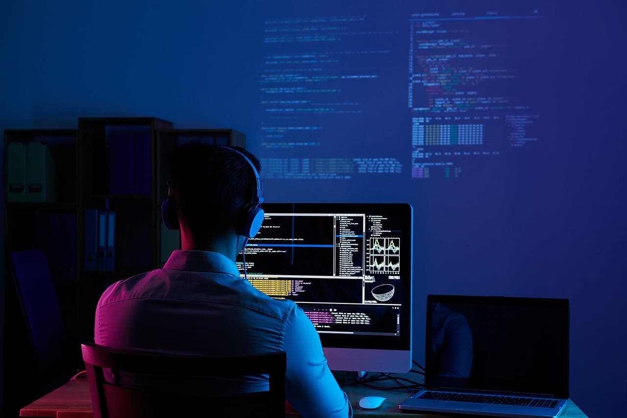Advertorial Wichtige Tipps für die Auswahl eines Unternehmens für kundenspezifische Software-Entwicklung software-developer-6521720_1280 Mensch mit Kopfhörern vor Monitor mit Codezeilen