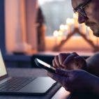 A man with a smartphone sits in front of a laptop late at night pvproductions via freepik https://www.freepik.com/free-photo/man-with-smartphone-sits-front-laptop-late-night_36802651.htm
