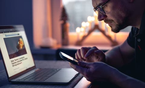 A man with a smartphone sits in front of a laptop late at night pvproductions via freepik https://www.freepik.com/free-photo/man-with-smartphone-sits-front-laptop-late-night_36802651.htm